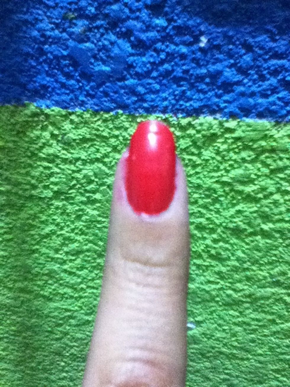 Apply a base coat on your nails after that add two coats of a red polish in all your nails except for your middle finger