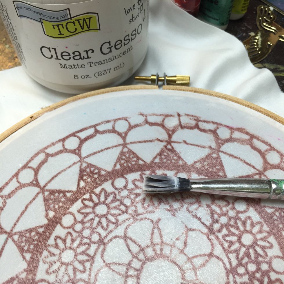 Apply a coat of clear gesso to prep the fabric for painting