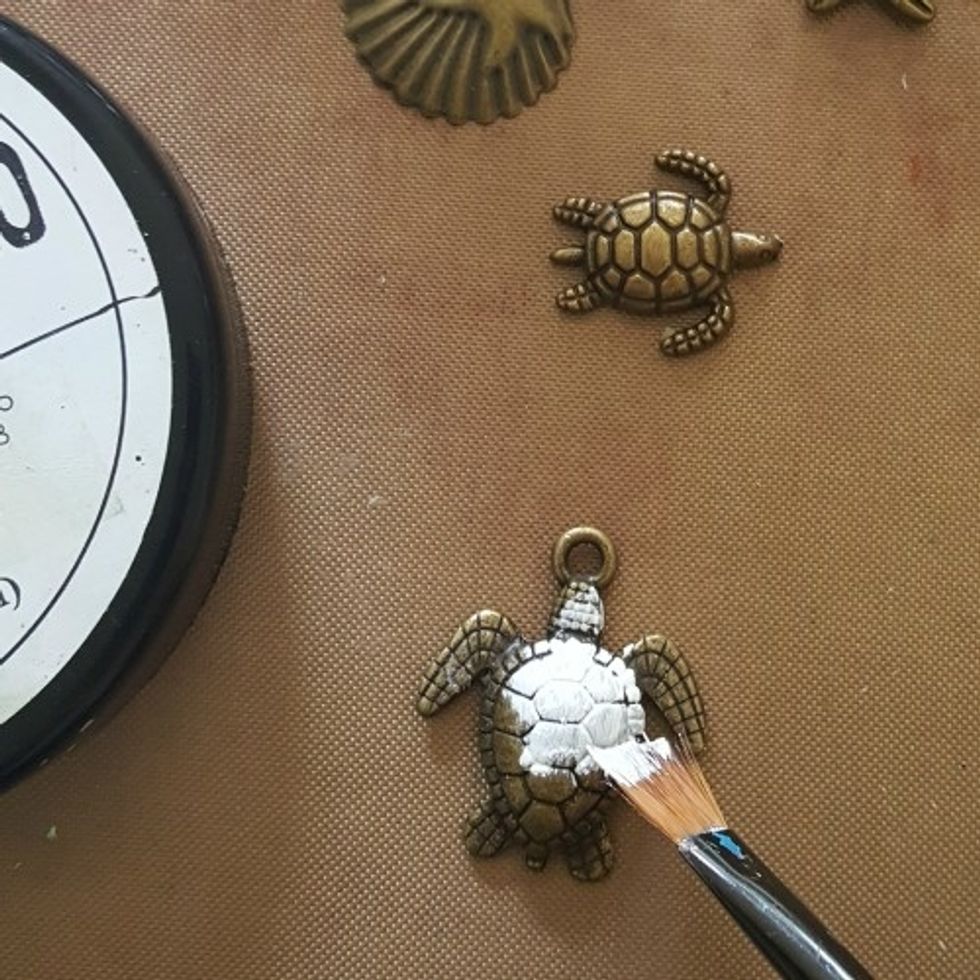 apply a coat of gesso to the metal embellishments