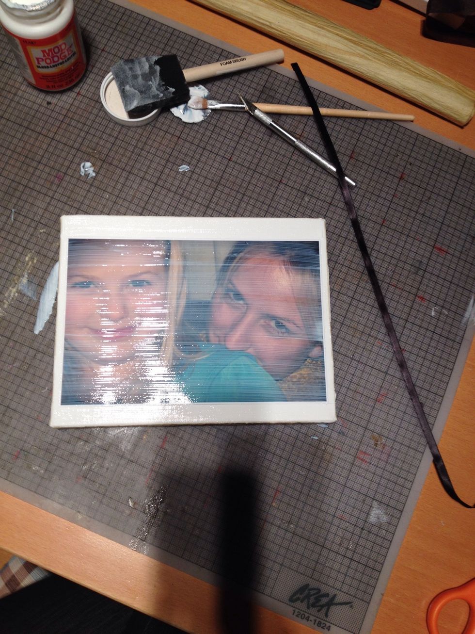 Apply a coat of mod podge over the entire surface the edges and the picture. Allowed to dry completely again. It will look milky at first, but will dry clear.