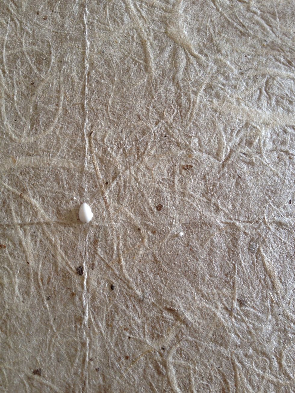 Apply a dot of wood glue to the center and all four corners of your board, then set your last sheet of paper on top (this step is if you need more than on sheet of background paper)