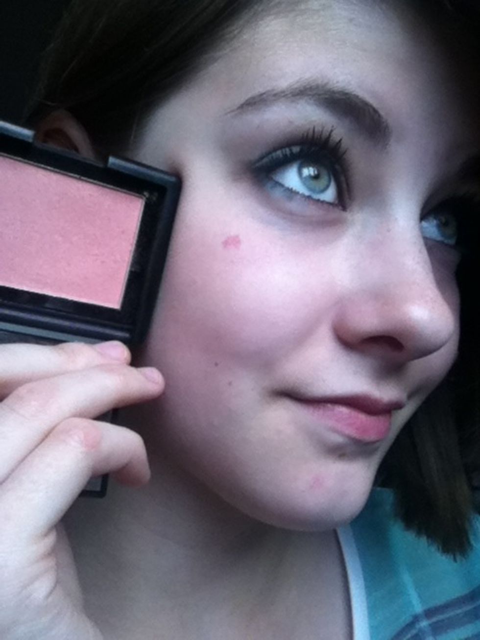 Apply a light pink blush to the apples of your cheeks and some light red lip stain to your lips.