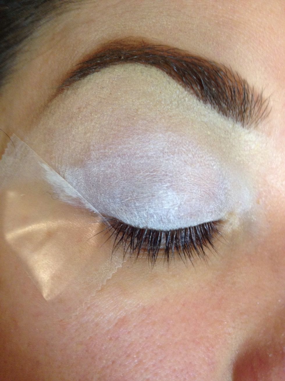 Apply a piece of tape to the corner of your eye to create a crisp line. Apply NYX Milk to lid.