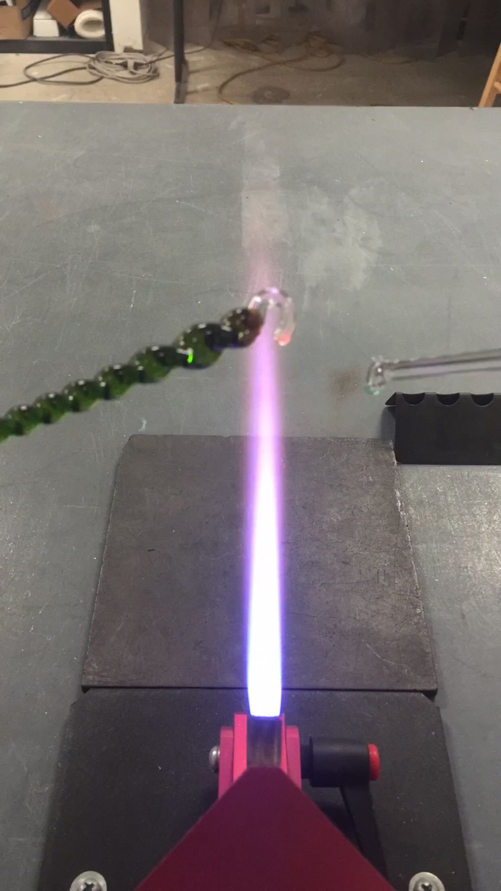 Apply a slight heat to the base of the clear hook to barely soften it. Then use a mandrel or cold piece of glass to push it into position. To avoid strain, don't close the loop. Leave a little gap.