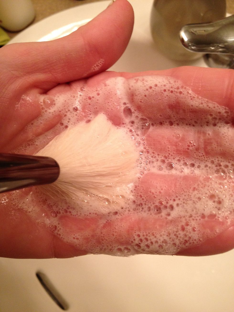 Apply a small amount of brush soap to your hand.  Use swirling circular motions to gently remove build up from the head of the makeup brush.