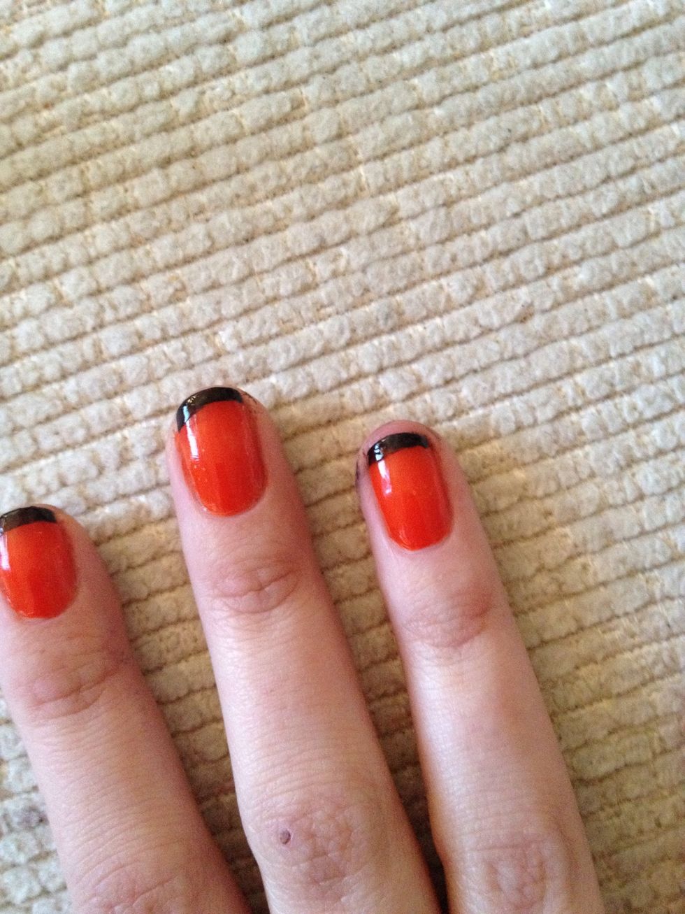 Apply a thin line in black nail varnish to the top of the red nails.