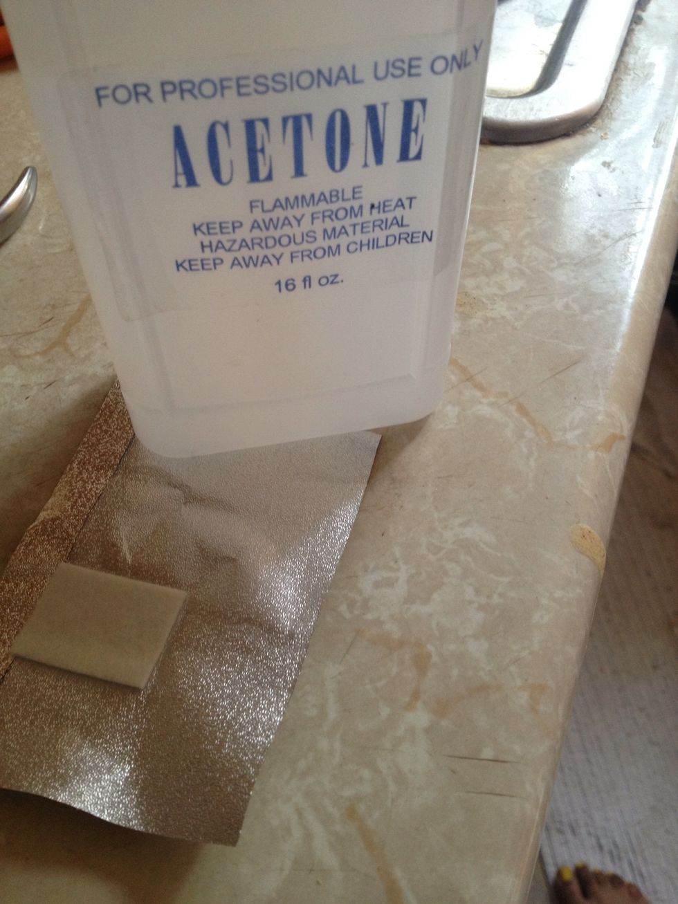 Apply acetone to the square cotton pad
