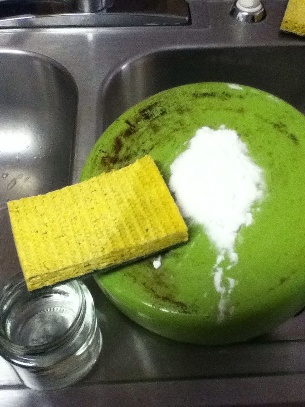 Apply baking soda to the pot and moisten one corner of the sponge.