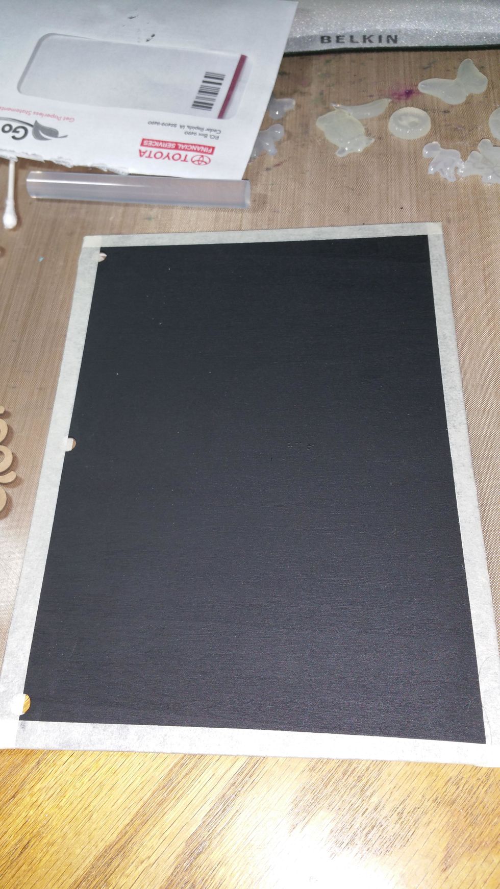 Apply black gesso to front and back and dry completely. Using masking tape or painters tape (both work) tape around the outside the desired amount of outline you'd like. Mine is approximately 1/2"