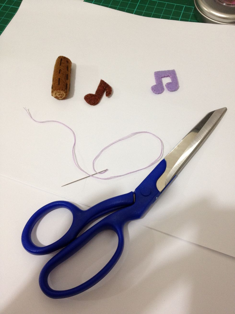 Apply columns of random size running stitches on a piece of brown fabric. Put two pieces of light brown fabric for the two sides of the "wood"! (don't forget the stuffing!) And sew the music notes.