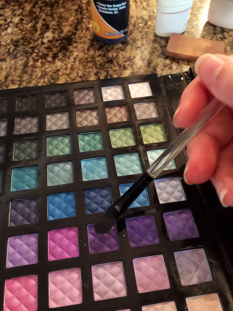 Apply dark purple eyeshadow to a make-up brush.