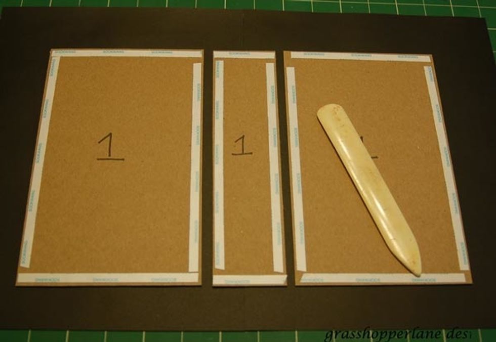 Apply double sided tape to all four sides of your chipboard pieces. There should be (2) 9 1/2 x 4 1/2 pieces and (1) 4 1/2 x 1 1/4 piece. Flip over and repeat on the other side.