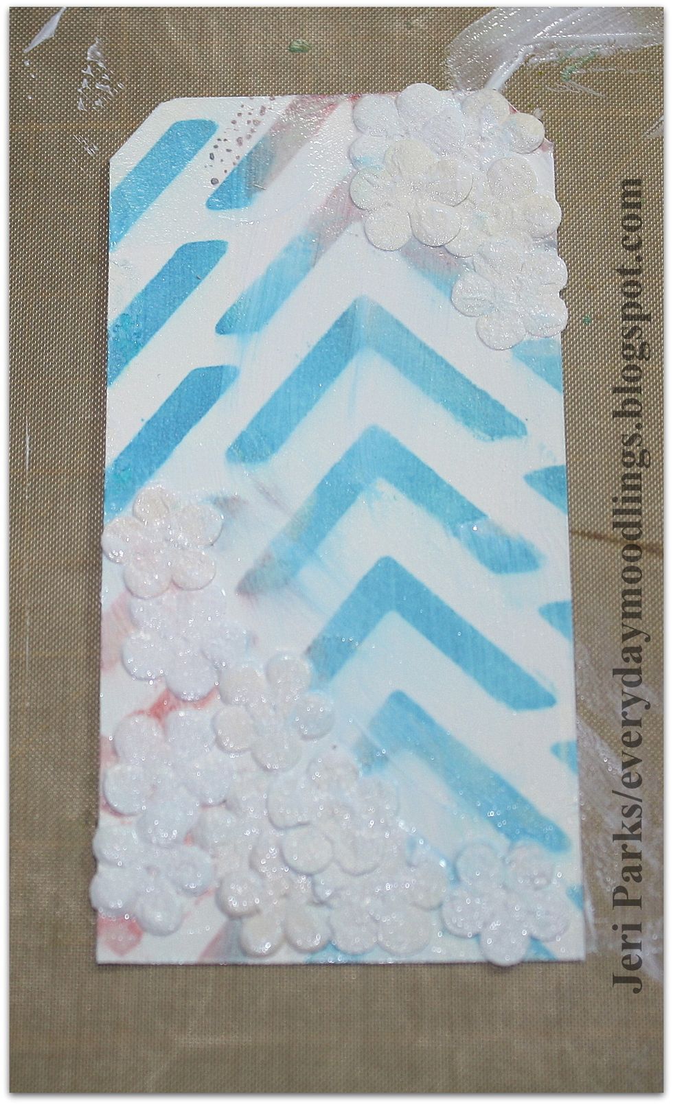 Apply flowers with matte medium mixture. You can add them to the entire tag or just sections of the tag. Cover the entire tag with the matte medium mixture to seal in the flowers. Allow time to dry.