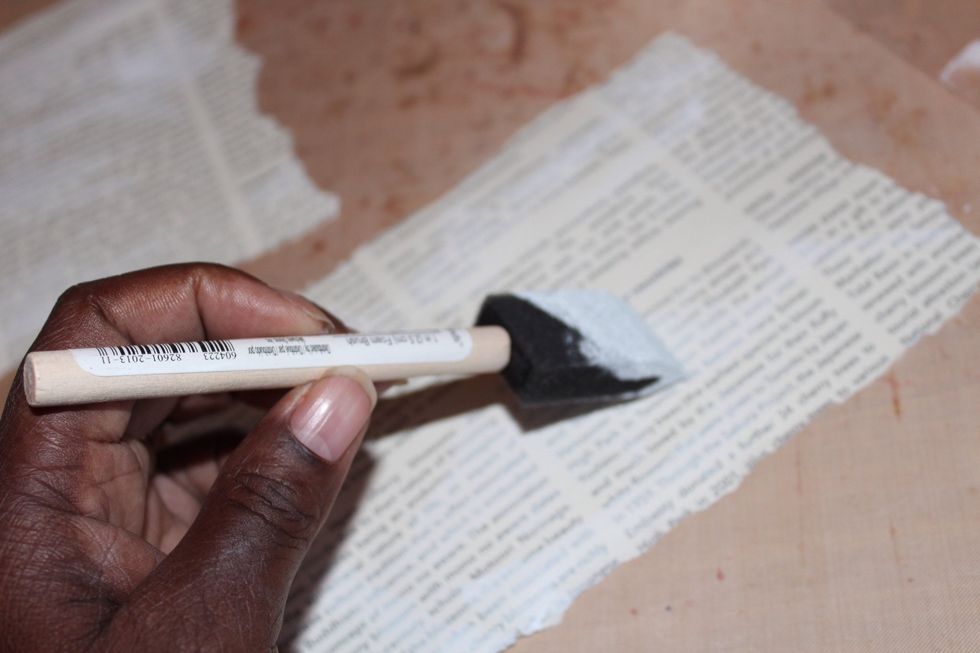 Apply gesso to layers of torn patterned paper using foam brush.