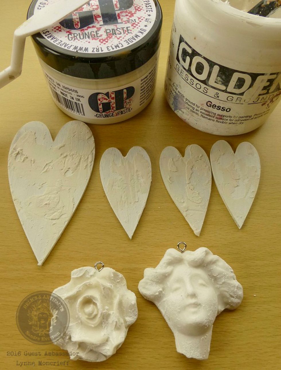 Apply Gesso to one large and three small MDF hearts. When Gesso is dry apply Grungepaste to hearts with palette knife, apply to the Facia Familiaris & Flora using your fingertips