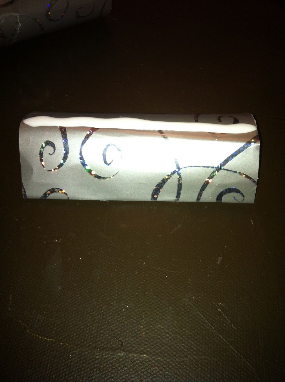 Apply glue in the center of the base. Align the napkin holder's center on the base and wait for it to dry. The type of glue depends on the decorating material used.