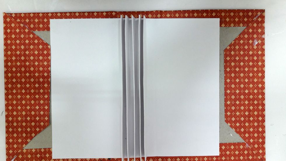 Apply glue on bottom of binding mechanism and attach to the center of cover and the sides. After the glue is dry close the cover gently.