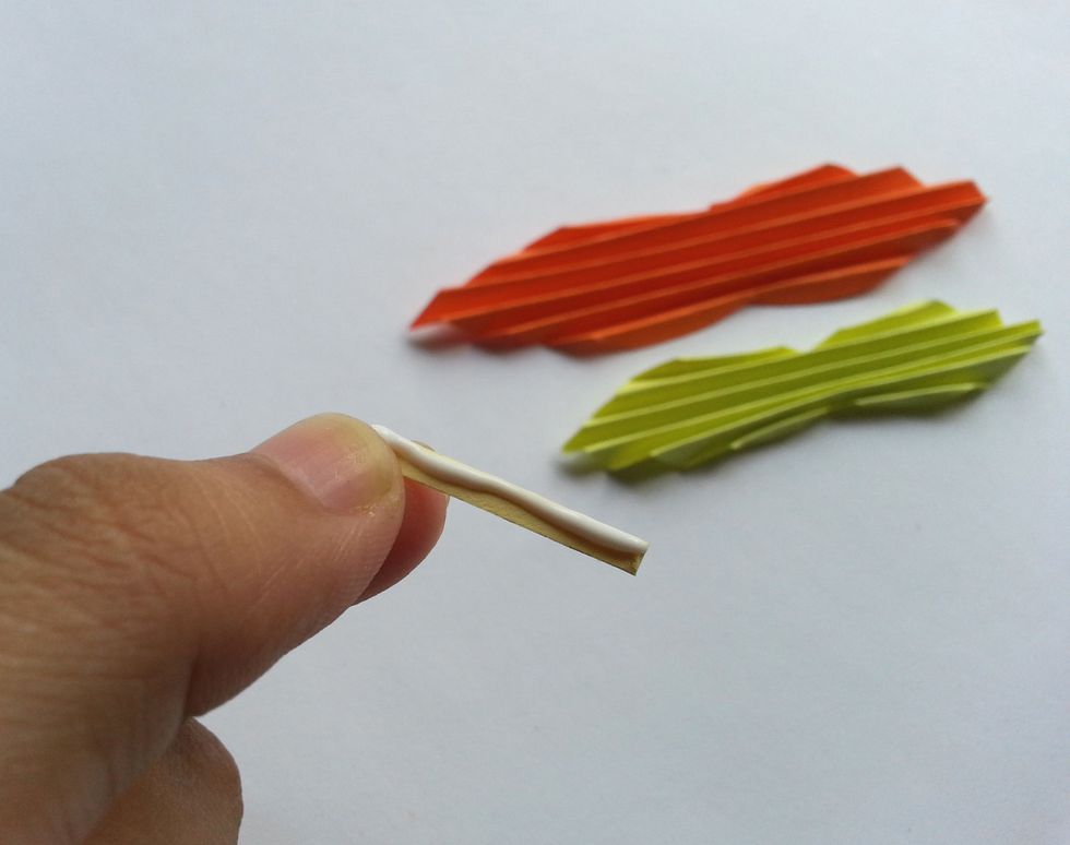 Apply glue on the piece of paper we've cut out for wrapping the wings together.