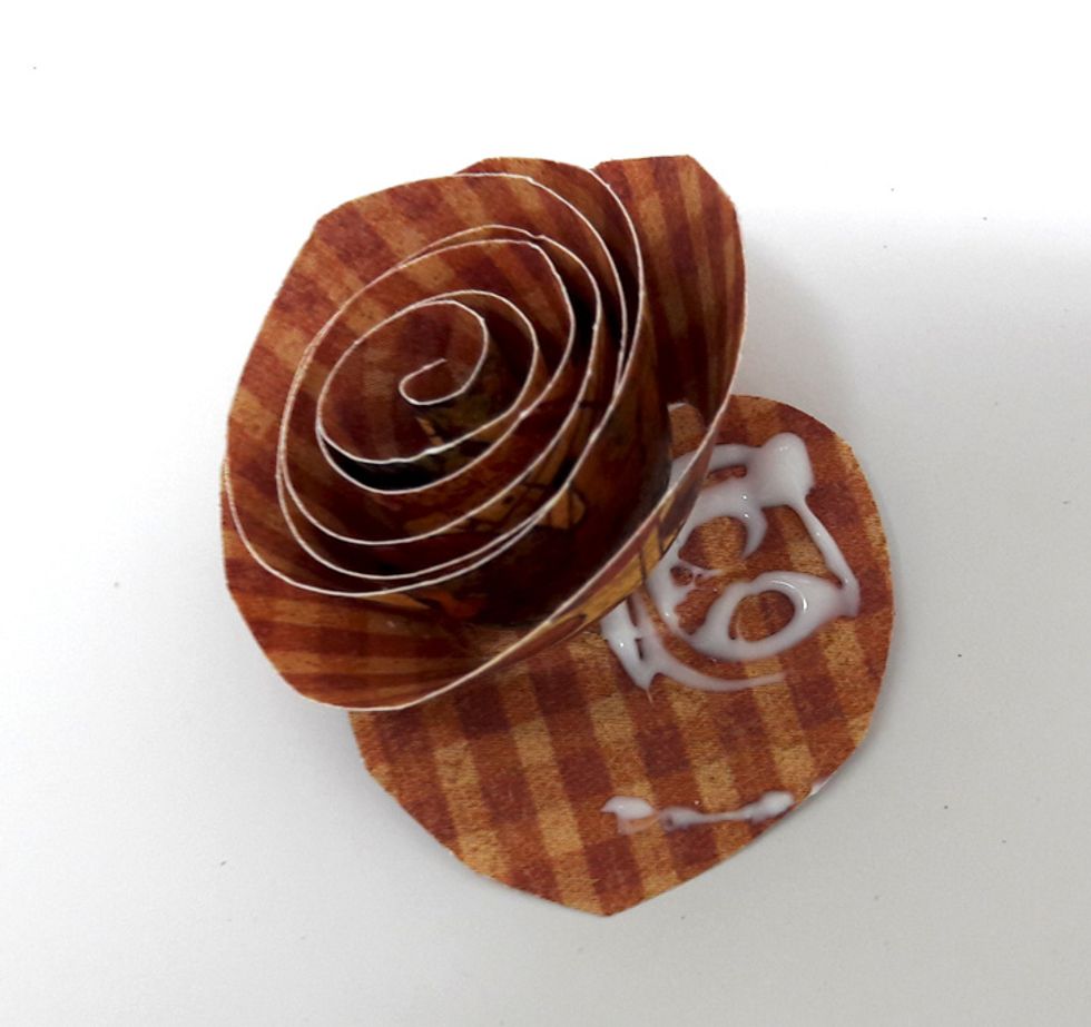 Apply glue to bottom of spiral and secure flower.