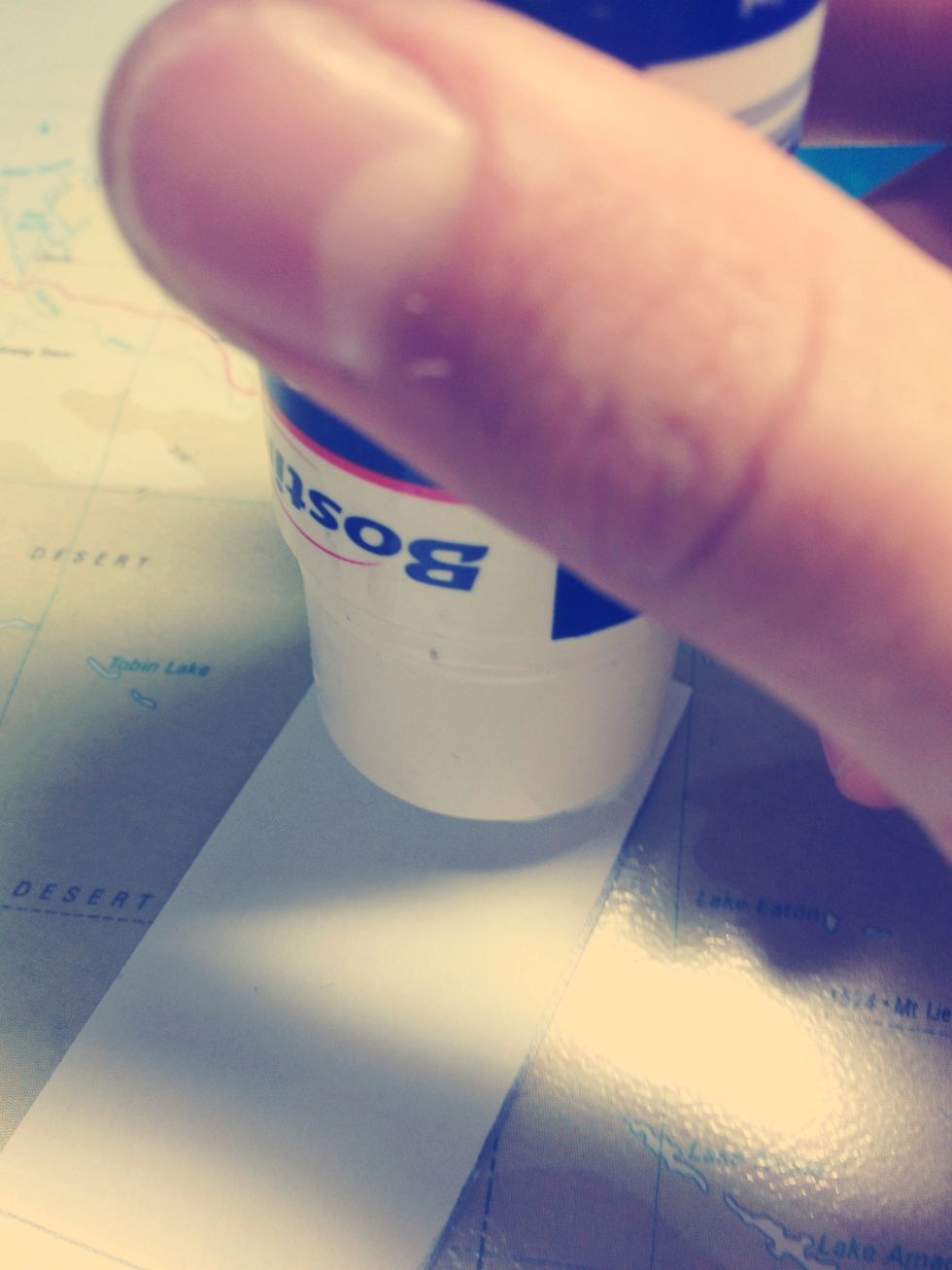 Apply glue to one edge of one piece of paper (the bottom piece).