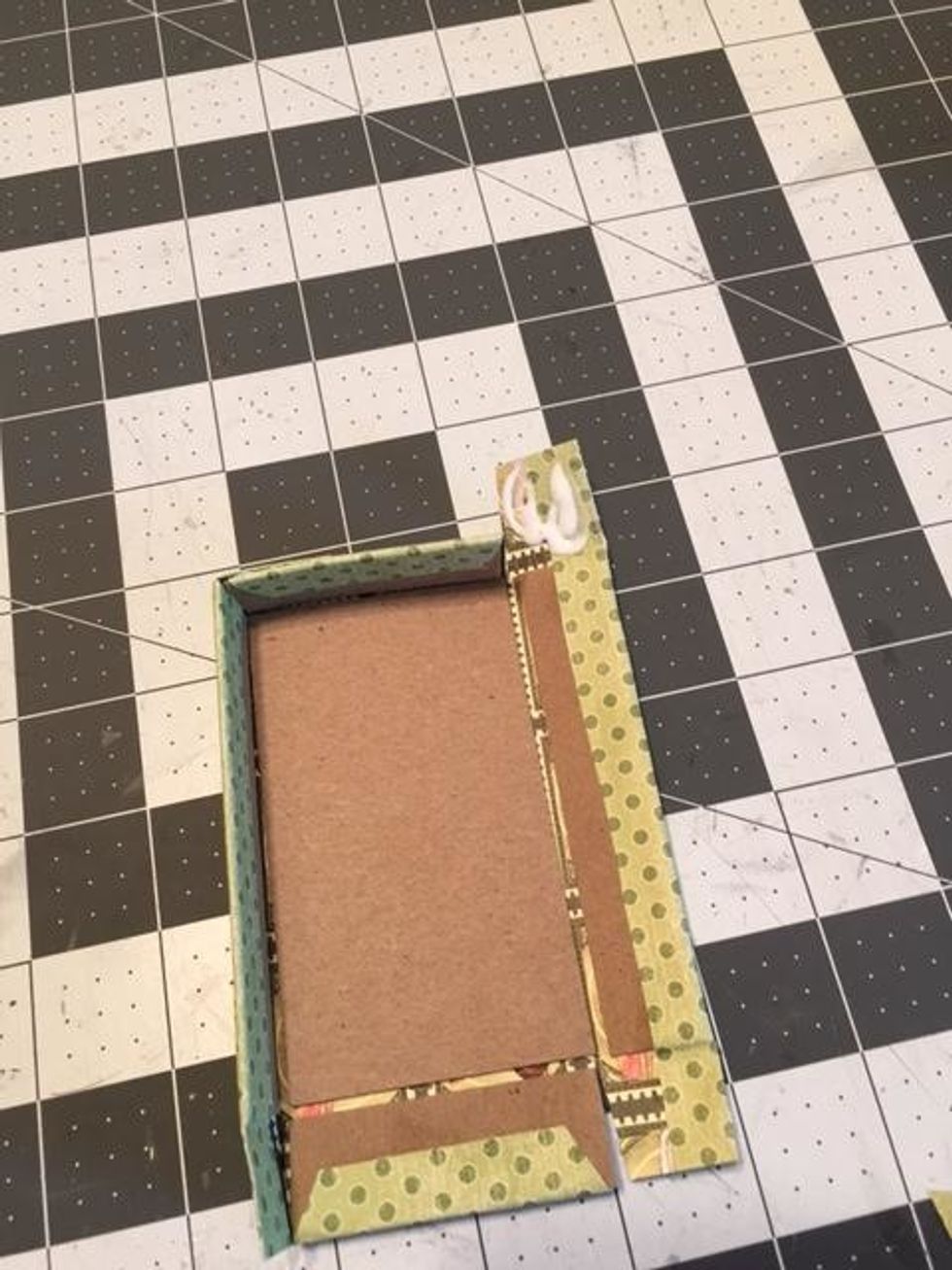 Apply glue to the back side of each flap and pull up the chipboard to form a box. Line up the corners and attach the flap to the outside of the short sides.