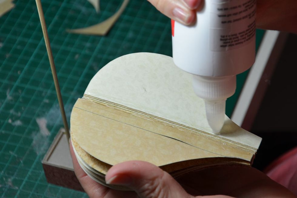 Apply glue to the spine of the balloon.