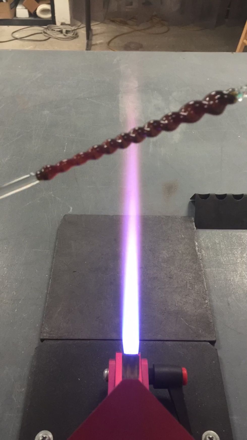 Apply more heat where you want it to become more narrow, while rotating and applying a subtle twist to create a tapered spiral.