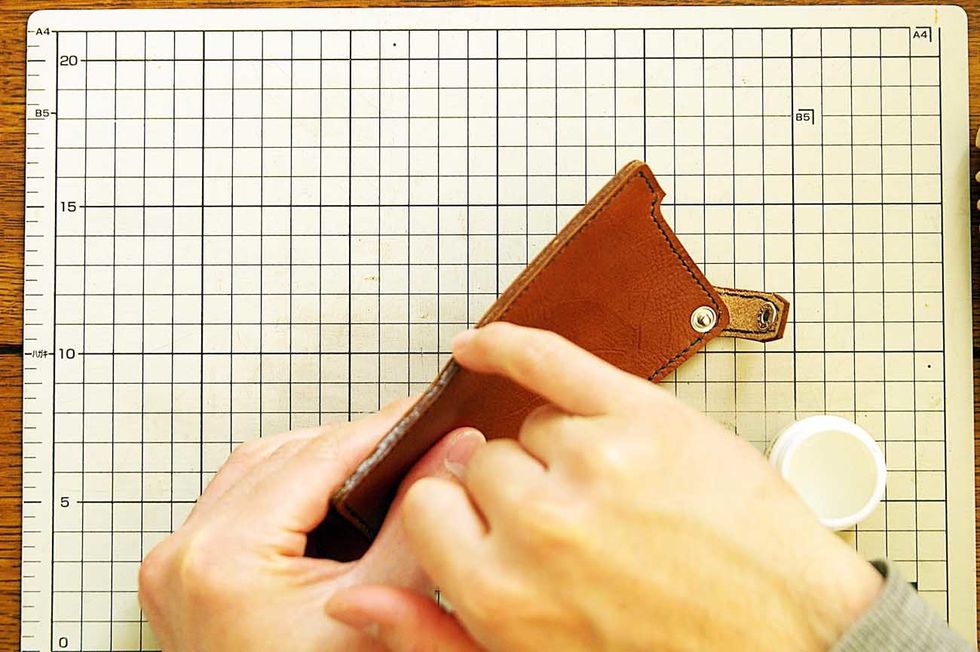 Apply oil to the leather edge and polish it with the stick of the wood.