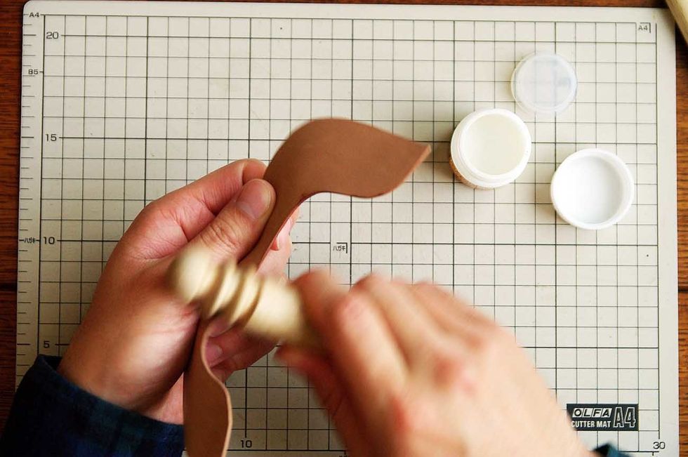 Apply oil to the leather edge and polish it with the stick of the wood.