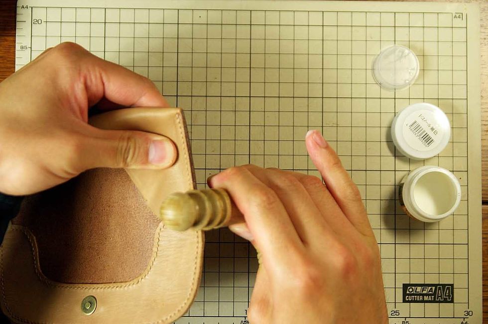 Apply oil to the leather edge and polish it with the stick of the wood.
