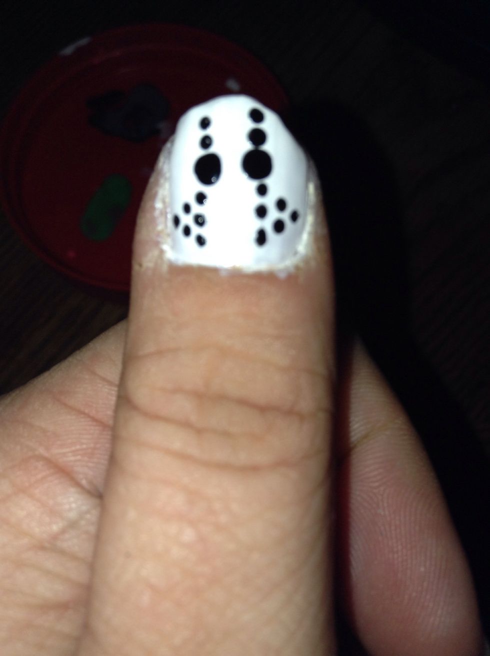 Apply one small black dot on the outside of each bottom set of two dots. Allow black polish to dry completely, then apply your topcoat. Finish the rest of your nails to suit your theme.