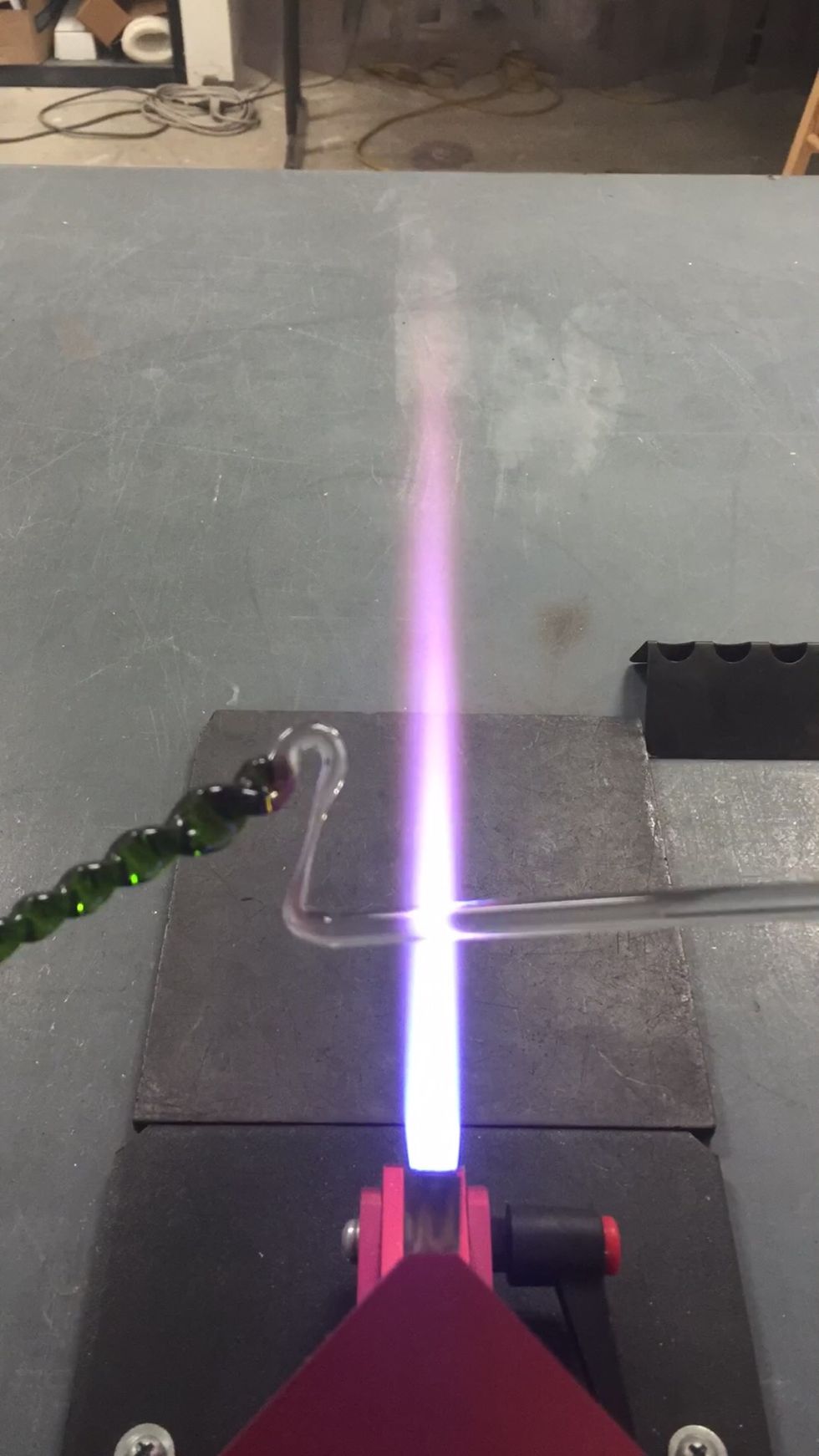 Apply some heat at the intersection of the stretched clear and the solid rod, and pull it thin in preparation for flame cutting.