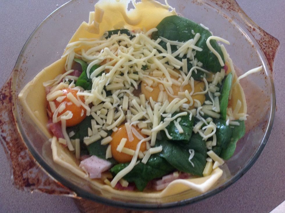 Apply spinach leaves on bacon then crack the eggs on the leaves sprinkle with salt and pepper then add desired amount of cheese