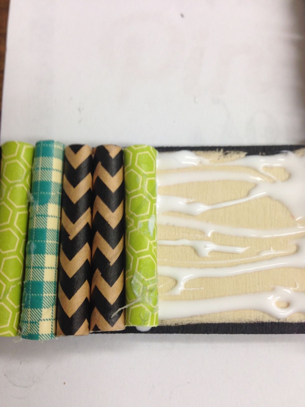 Apply tacky glue and set straws in place. Work in small sections at a time around the frame. You will have room for 24 pieces on both long sides and 12 pieces on both short sides.