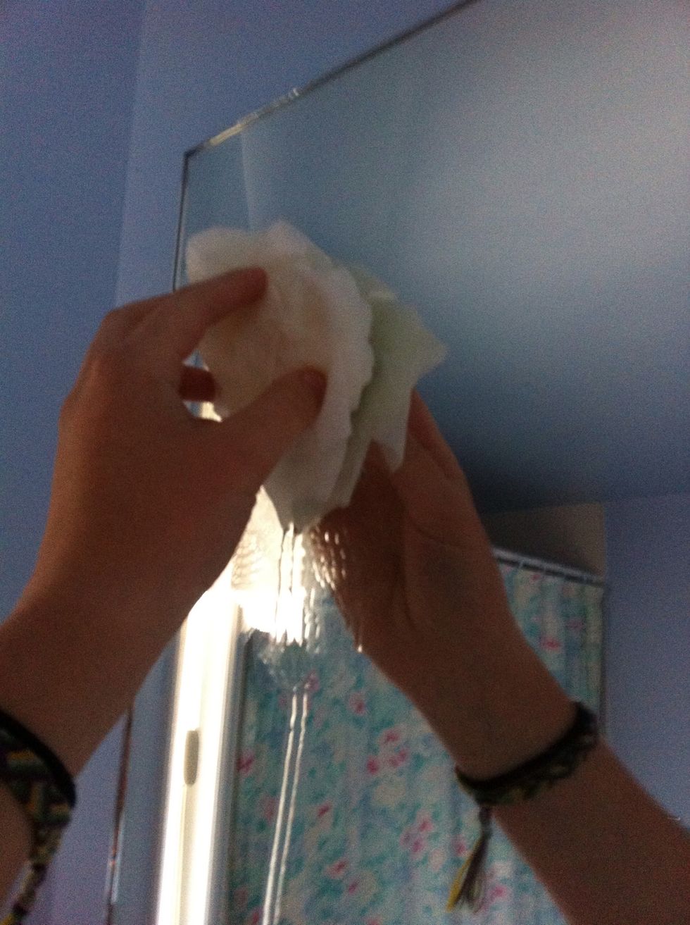 Apply the paper towel to the mirror with a side sweeping motion, make the mirror all wet.