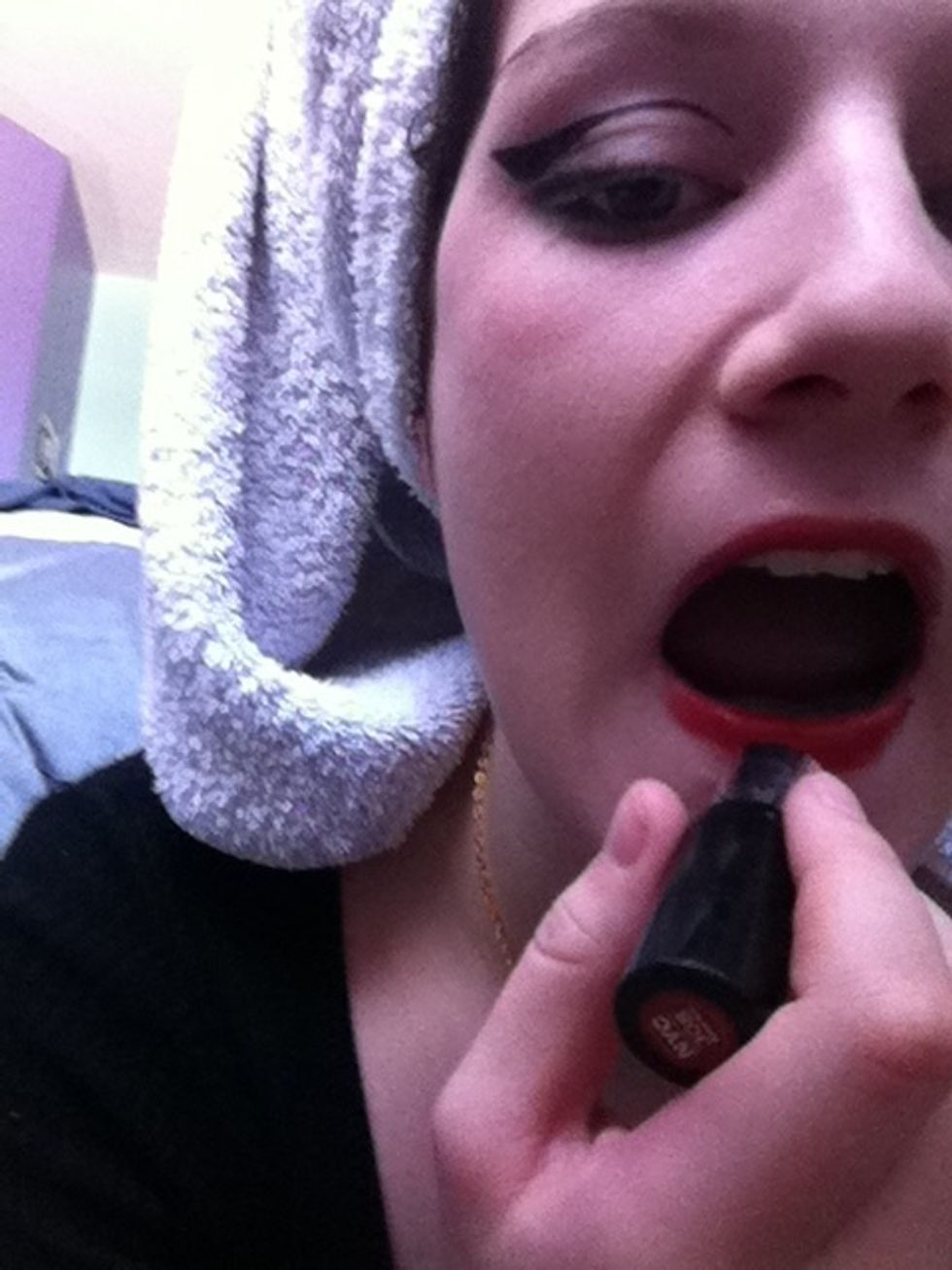 Apply the red lipstick, smoothing out your lips as shown above ensures complete smooth coverage