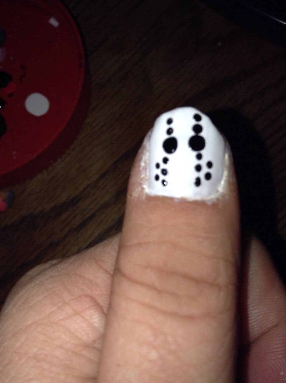 Apply two small black dots beside each of the sets of three dots, on the outside edge.