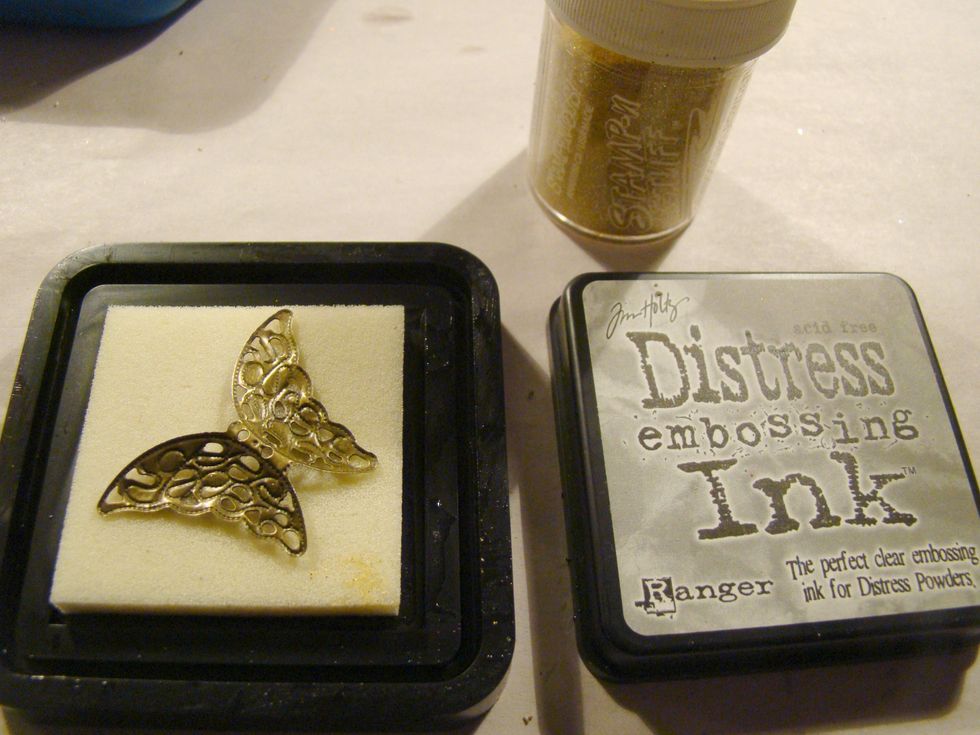Apply Versamark or DI Embossing Ink to metal butterfly and using gold embossing powder heat. Be careful, metal gets very hot when heated.
