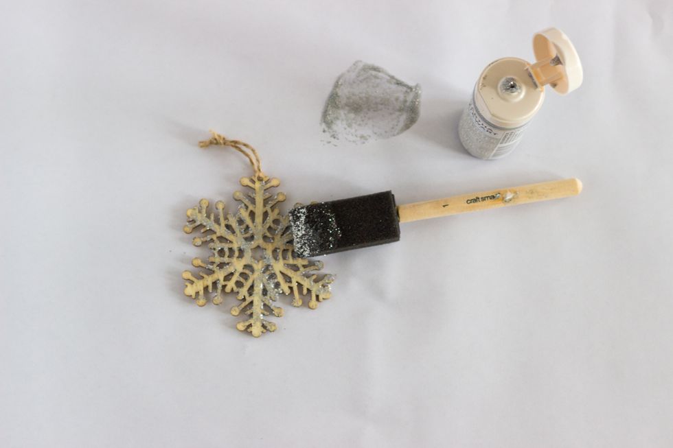 Apply your first coat of glitter paint to the wooden snowflake. Wait one hour between coats. Give your snowflake a second coat of glitter paint.