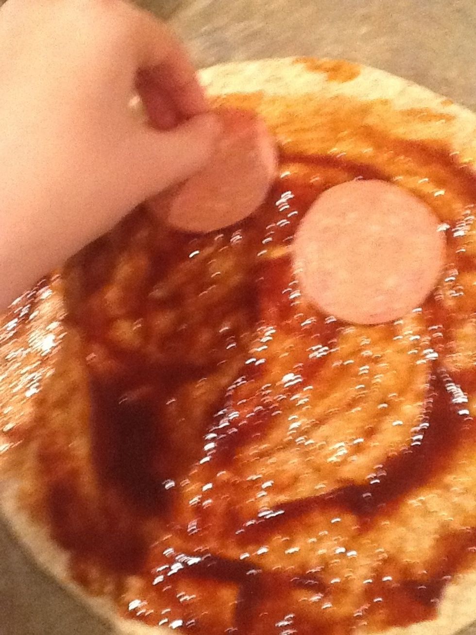 Apres to as mettez de la sauce BBQ sur la pate, tu veux ajoutez du pepperoni sur la pate.