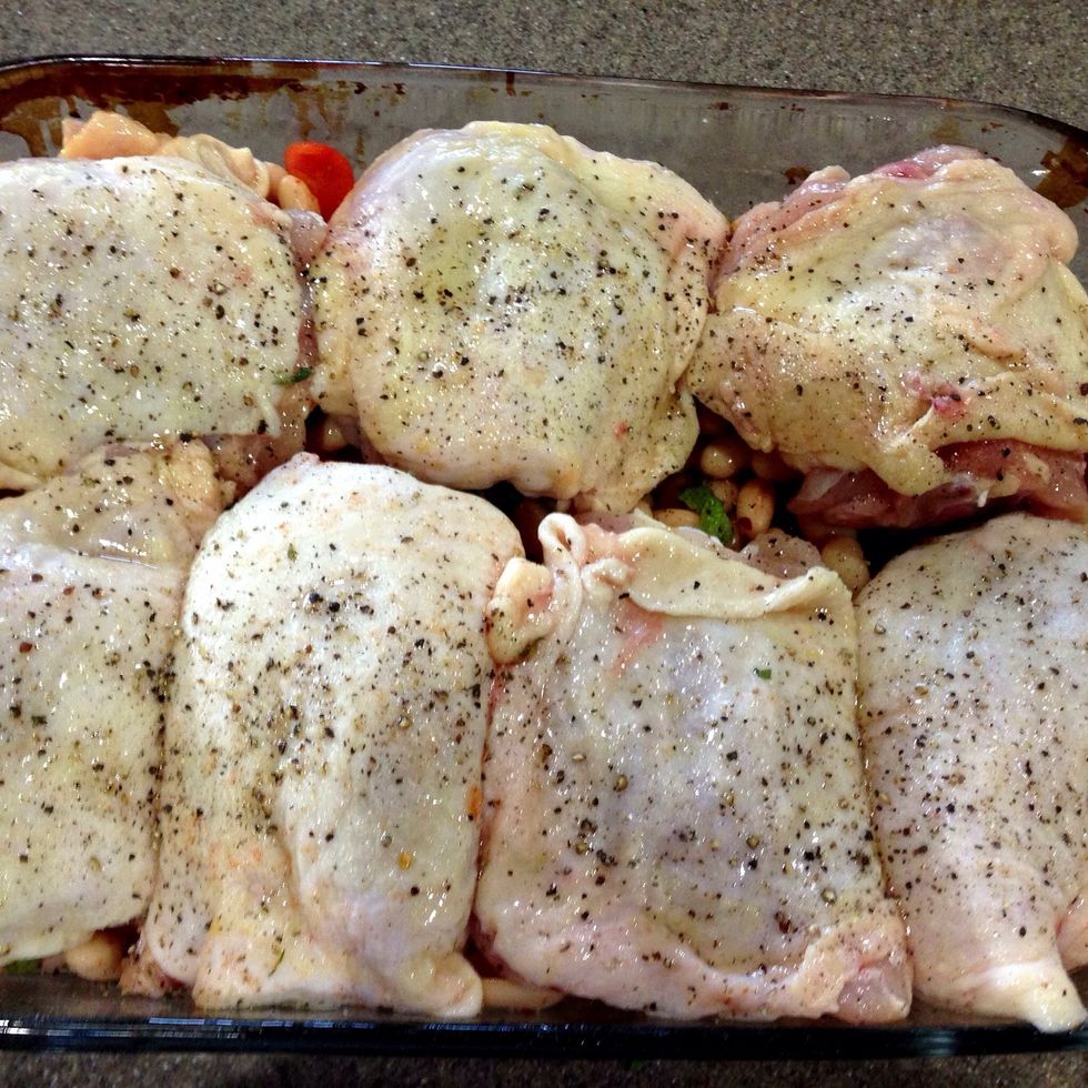 Arrange chicken thighs skin side up on top of the beans. I always have more thighs than space, so I cook the extras in their own pan. Sprinkle liberally with sea salt & pepper.