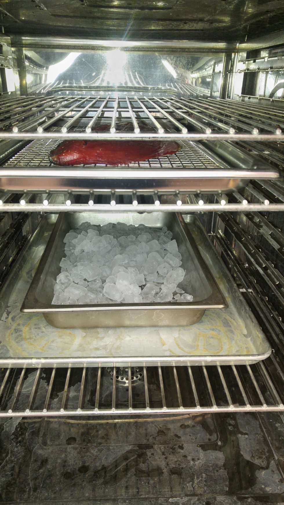 arrange oven with a sheet pan to deflect the direct heat, then a pan of ice to keep oven cool and the salmon above it on the wire rack.