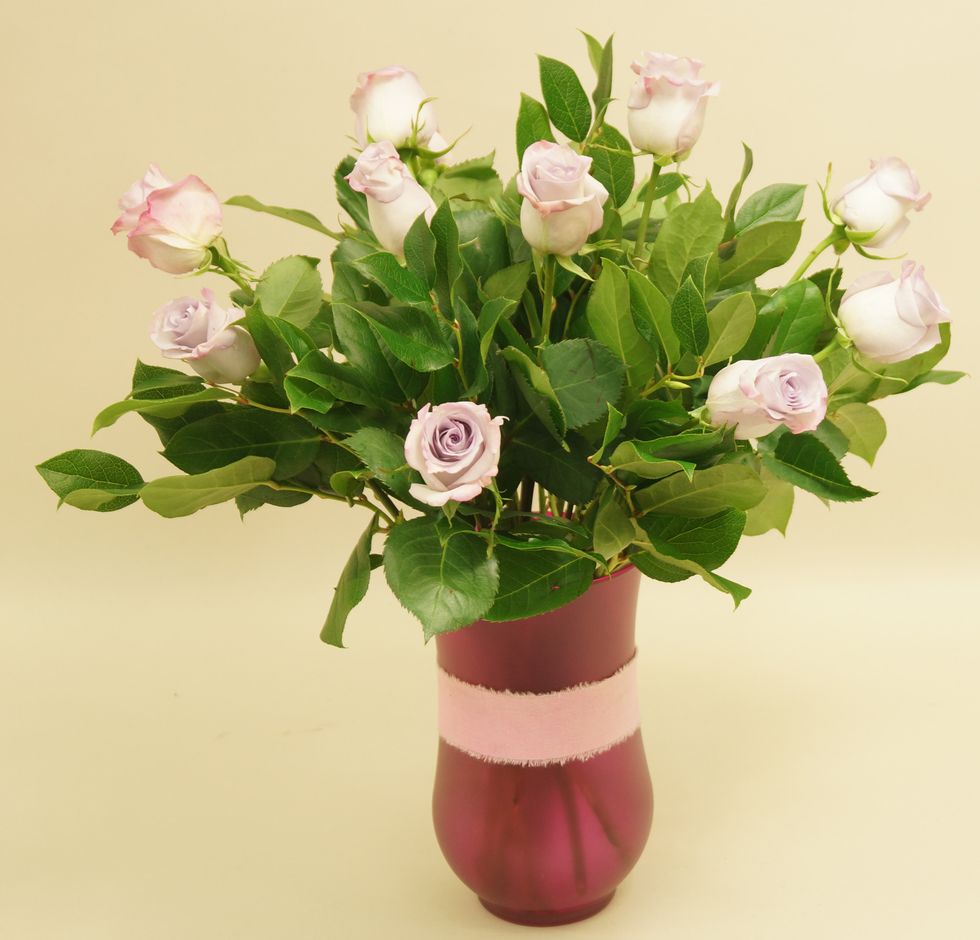 Arrange salal and roses in vase.