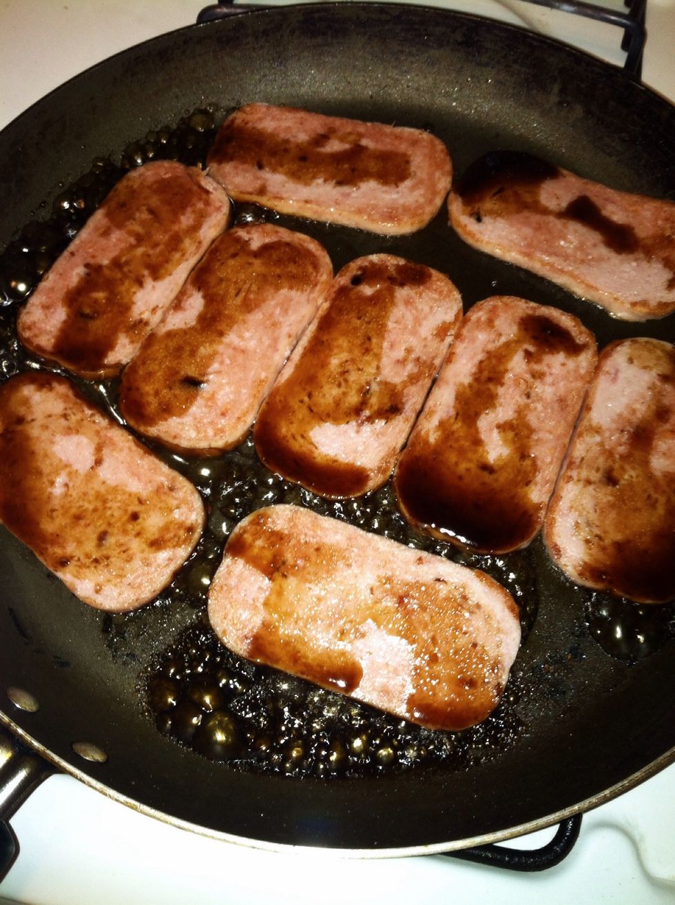 Arrange Spam in pan and heat over low to medium heat. After about 1 to 2 minutes, pour the soy sauce/sugar mixture over the Spam.