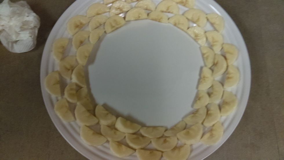 Arrange the banana slices in a circle on a plate.