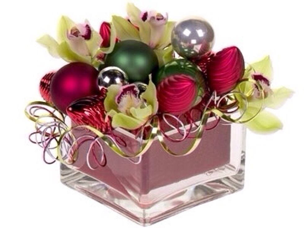 Arrange the ornaments to cover the top section of exposed foam. Then nestle, the orchids in being sure to hide the water tubes.