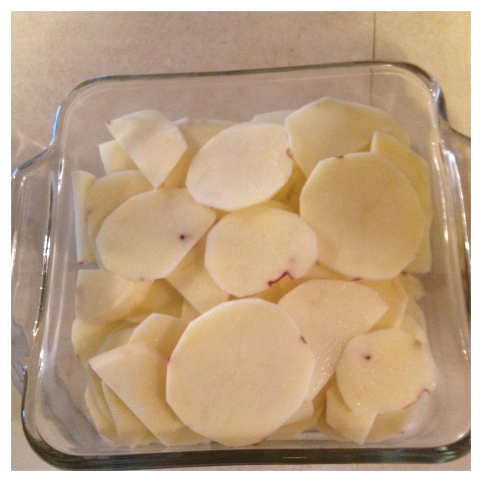 Arrange the potatoes in the sprayed baking dish.