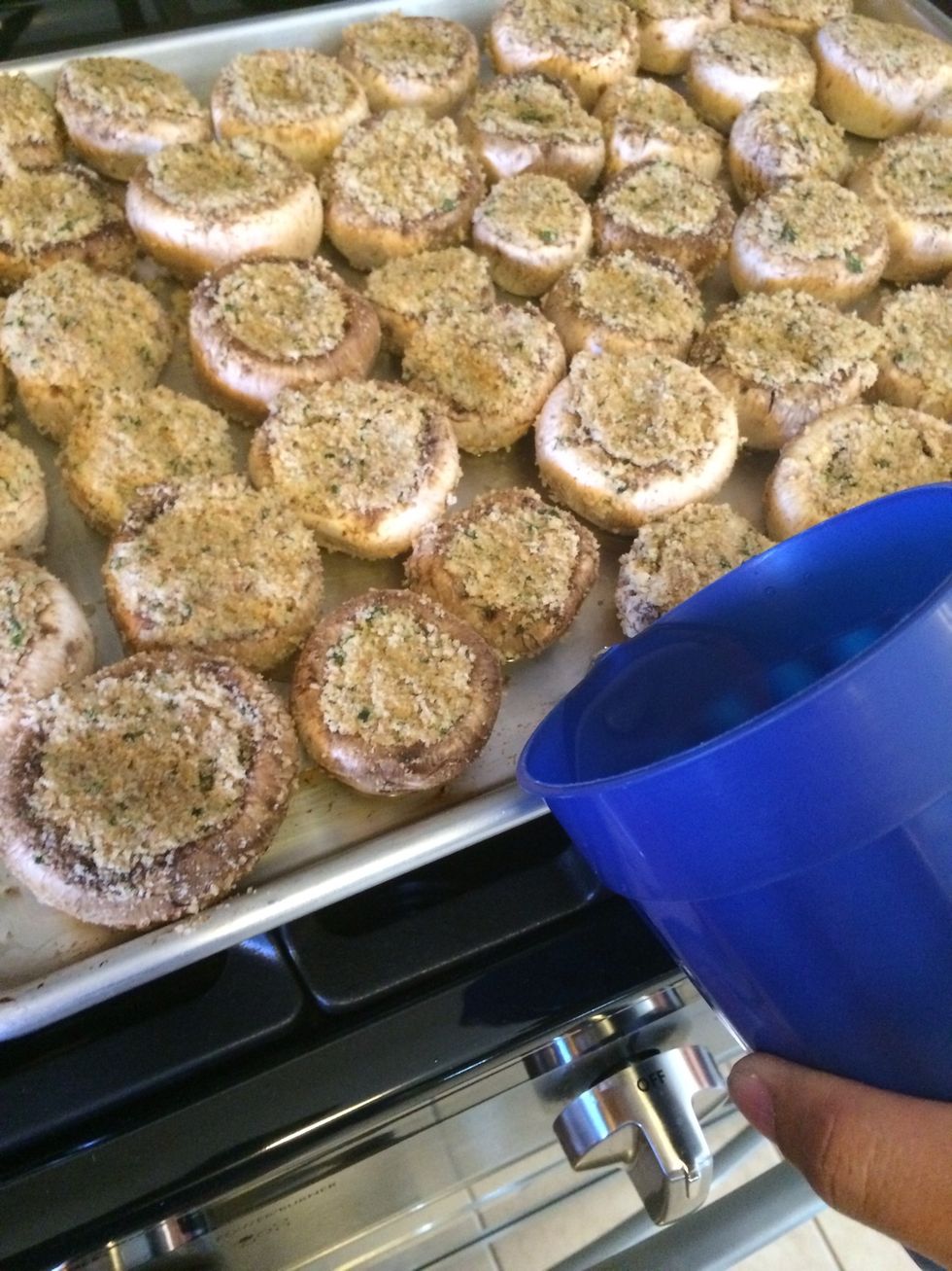 Arrange the stuffed mushrooms on a cookie sheet. and add enough water so that each mushroom is surrounded by water. This will prevent our shrooms from drying out.