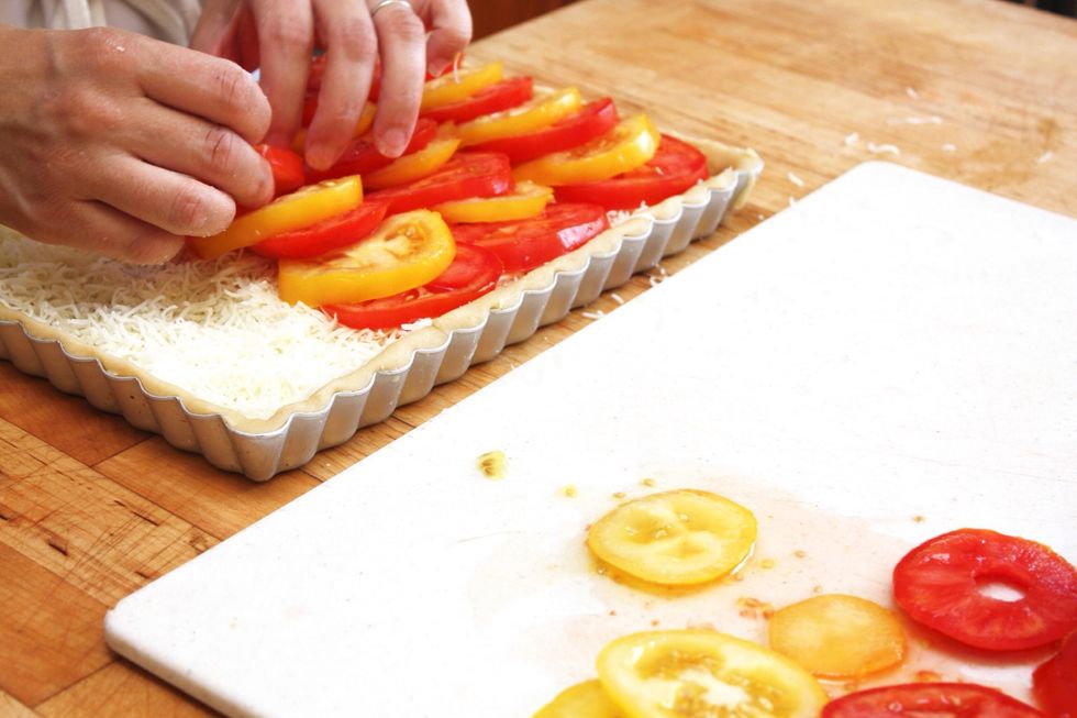 Arrange the tomatoes over the cheese. If using more than one color of tomatoes, decoratively lay them in a pattern.