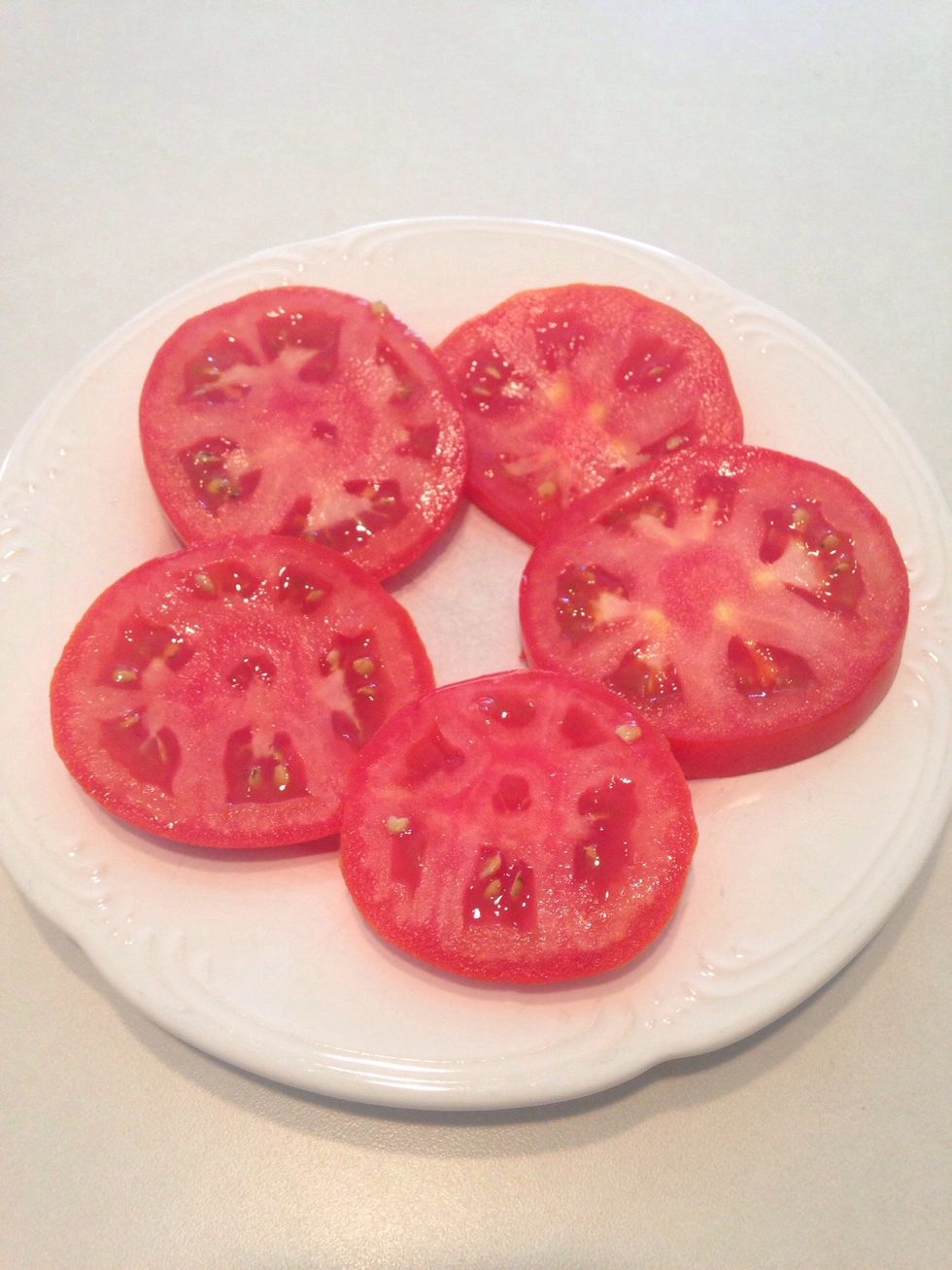 Arrange tomatoes on a plate.
